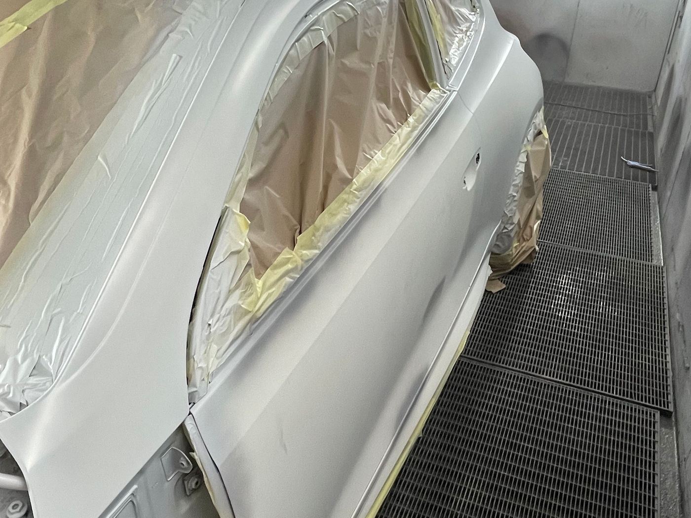 A silver panel masked up inside the N17 Bodyworks spray booth