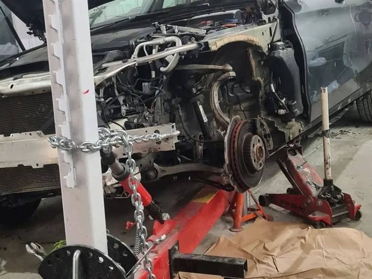 Car front end stripped to the chassis and set up on an alignment jig