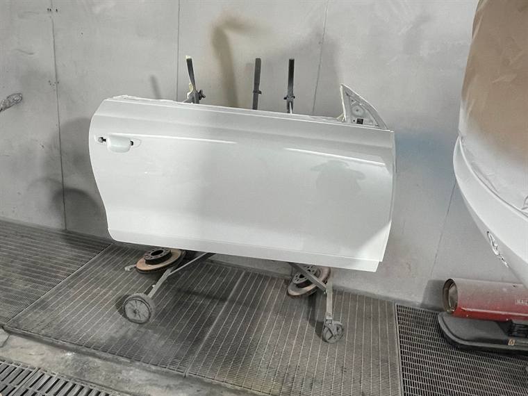 A white door skin on a stand inside the spray booth